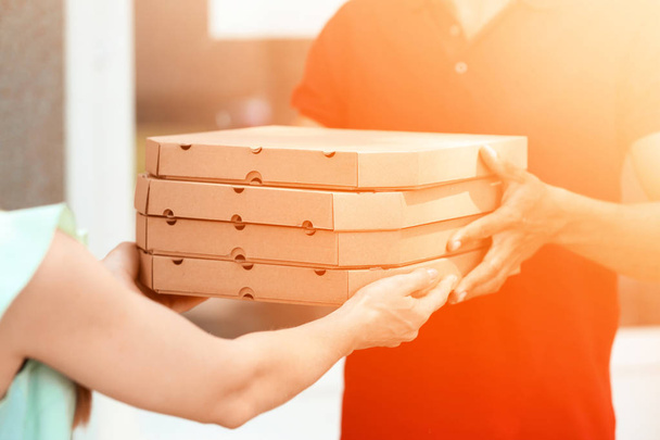 Mulher levando caixas com pizza saborosa de correio
 - Foto, Imagem