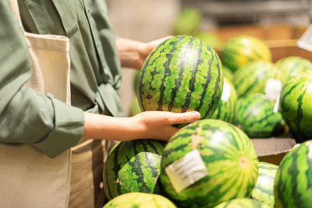 Woman choosing watermelon in market. Zero waste, plastic free concept. Sustainable lifestyle. Healthy food, bio, vegetarian diet concept - Φωτογραφία, εικόνα