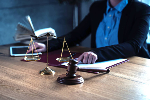 Tuomari työskentelee pöydässä lain ja oikeuden symbolien kanssa etualalla
 - Valokuva, kuva