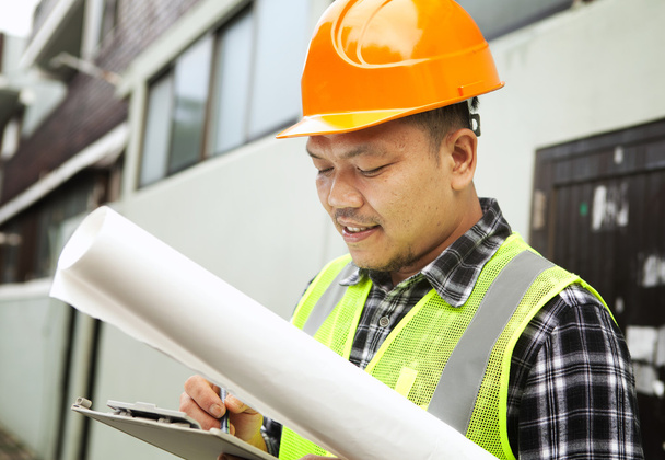 Trabalhador da construção masculino vestindo colete de segurança em um local de construção
 - Foto, Imagem