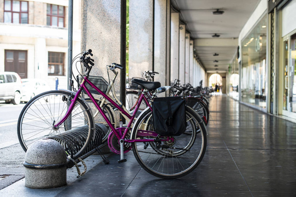 Bikes mounted on a bicycle stand on italian street.  - Zdjęcie, obraz
