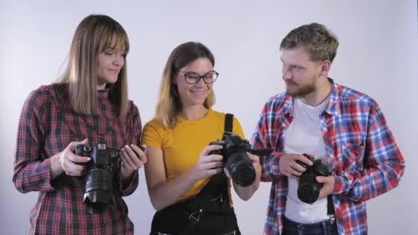 εκπαίδευση φωτογραφίας, νέοι επαγγελματίες διασκεδάζουν μελετώντας ψηφιακές φωτογραφικές μηχανές σε φωτογραφικά στούντιο κατά τη διάρκεια του εργαστηρίου - Πλάνα, βίντεο
