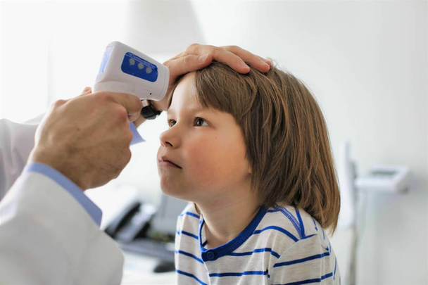 Cropped image of doctor measuring temperature of boy with infrar - Foto, immagini