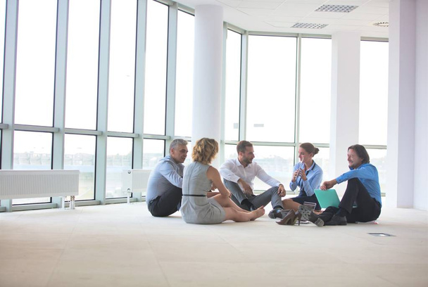 İş arkadaşları yeni ofiste yerde otururken tartışıyorlar. - Fotoğraf, Görsel