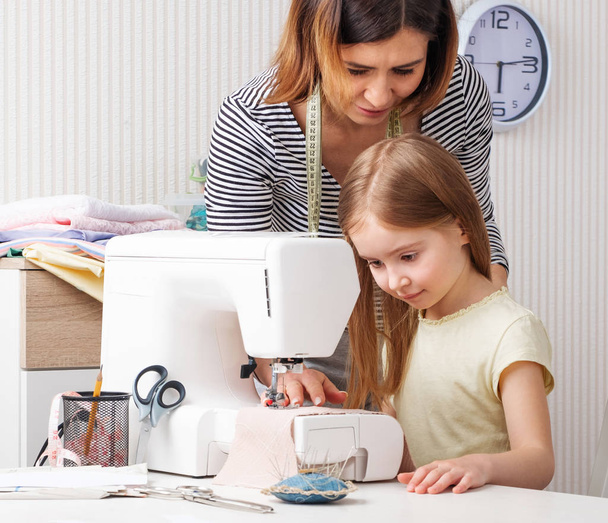 Woman showing to child how to sew at home - Photo, Image