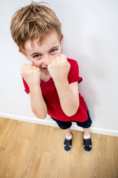 smiling boy showing his defense with fists protecting his face - Фото, изображение