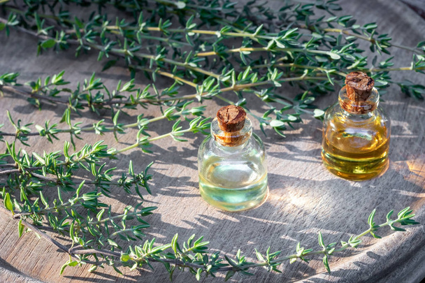 Bottiglie di olio essenziale di timo con timo fresco
 - Foto, immagini