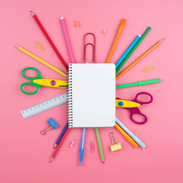 Kolorowe materiały szkolne na papierze na różowym tle - Zdjęcie, obraz