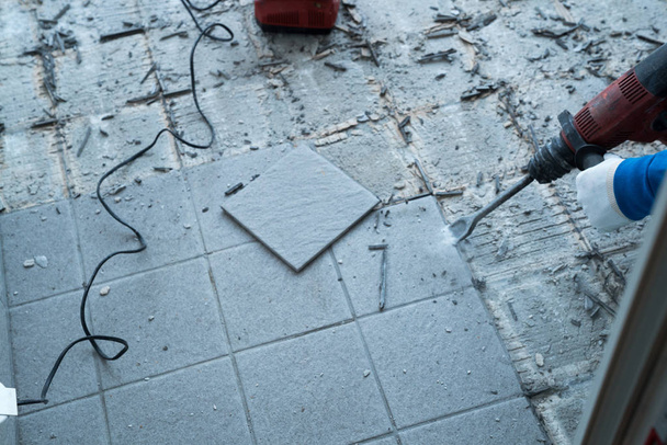 travailleur de la construction à l'aide d'un marteau de démolition portable et d'un mur
  - Photo, image