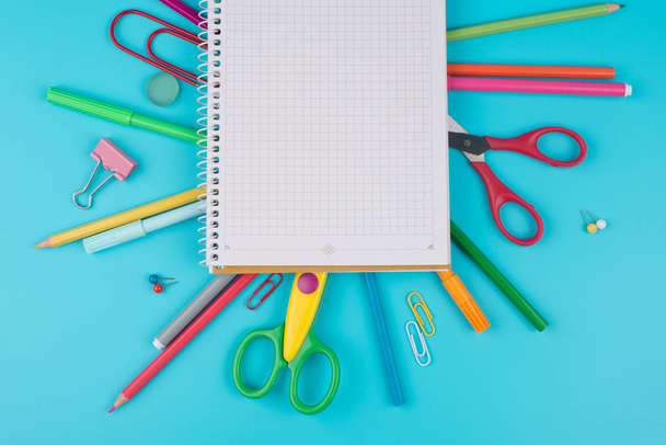 Colorful school supplies and notepadon a blue background. - Photo, Image