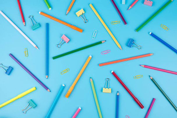 Coloridos útiles escolares y bloc de notas sobre un fondo azul
.  - Foto, Imagen