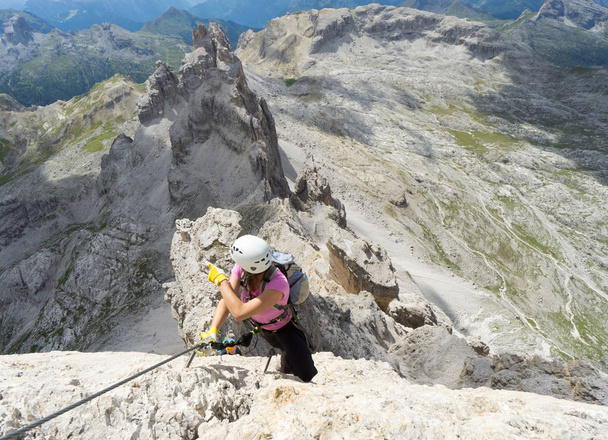 atraente morena mulher alpinista em um íngreme e exposto Via Fe
 - Foto, Imagem