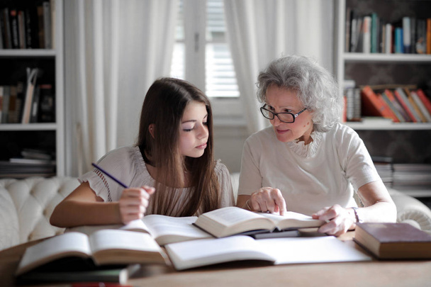 Granny and a little girl do homework - 写真・画像