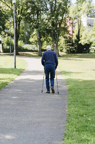 Homem mais velho andando com bengalas no parque
 - Foto, Imagem