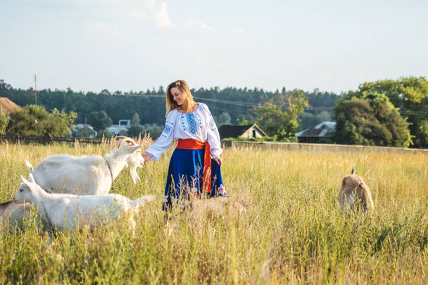 beautiful girl in national dress. bright national outfit. nature near the village. rustic motive. - Valokuva, kuva