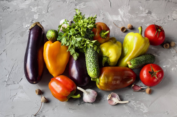 Autumn vegetables (bell pepper, eggplant, tomatoes, garlik, cucumbers)  on a grey grundge background. The concept of healthy and diet food. - Foto, afbeelding