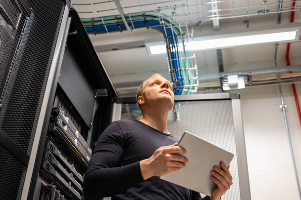 Male IT Professional Holding Digital Tablet Planning Changes in Datacenter - Photo, Image
