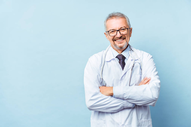 Cheerful mature doctor posing and smiling at camera, healthcare and medicine. - Photo, Image