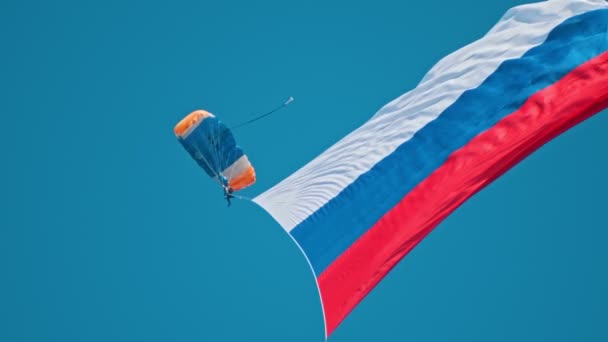 Mies lensi taivaalla laskuvarjo auki ja Venäjän lippu auki.
 - Materiaali, video