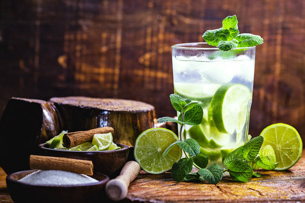 Mojito is a white rum-based cocktail made in Cuba. Tourist drink created in Havana. alcoholic drink on rustic wood background, image for menu or restaurant. - Zdjęcie, obraz