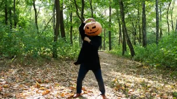 Man pumpkin head dancing in the forest, the sun shines brightly - Footage, Video
