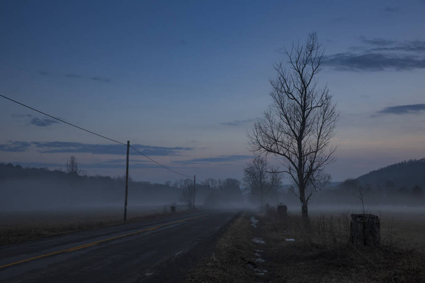 Una calda nebbia invernale infesta il paesaggio di Jenksville, una piccola città rurale nello stato di New York, composta da fattorie, strade a cielo aperto e strade di campagna a due corsie.
.  - Foto, immagini