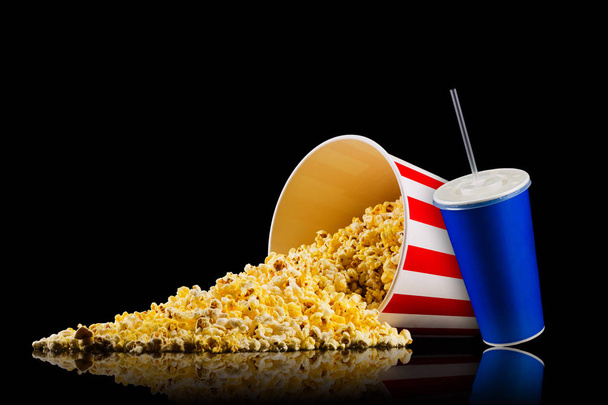 Paper striped bucket with popcorn, cup of drink and glasses isolated on black - Valokuva, kuva