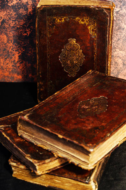 Una pila de viejos libros judíos encuadernados en cuero con estampado de oro sobre fondo negro
 - Foto, imagen