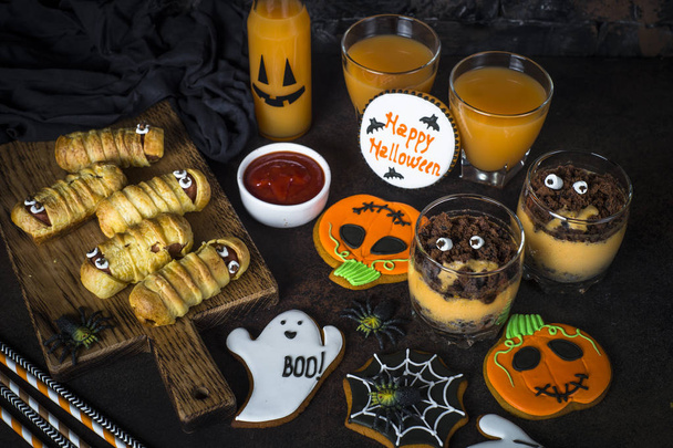 Halloween food assortment - sasage mummies, pumpkin dessert, gin - Foto, afbeelding