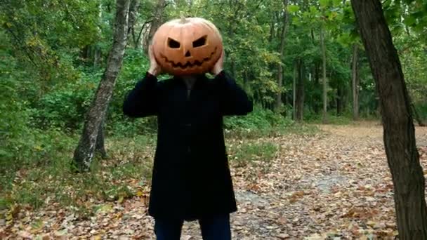 A man with a pumpkin on his head. He grabs his head and waves it. - Footage, Video