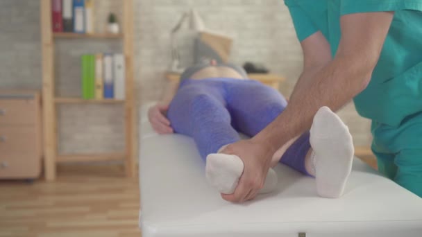 Terapeut ortopedem zpracovává ploché nohy sportovce - Záběry, video