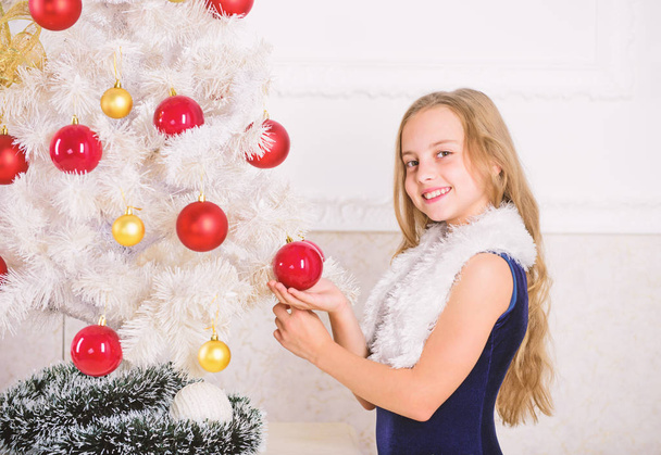 Winter holiday concept. Family holiday concept. Girl velvet dress feel festive near christmas tree. Very special time of year. Spread christmas cheer. Kid happy because holiday season arrives - Fotografie, Obrázek