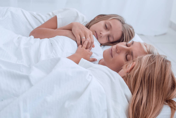 happy mother with her daughters are fast asleep together - Foto, Imagem