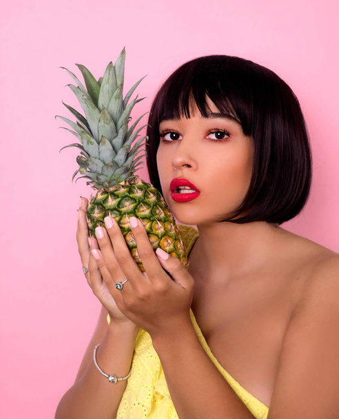 Young woman posing with pineapple  - Фото, изображение