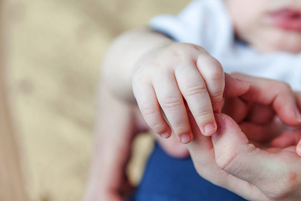 Μικροσκοπικό νεογέννητο βρέφος αρσενικό ή θηλυκό μωρό χέρι κρατώντας το δάχτυλο της μητέρας - Φωτογραφία, εικόνα