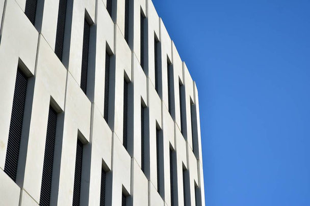 Nowoczesny budynek biurowy szczegółowo. Widok perspektywiczny geometrycznych kątowych okien betonowych na elewacji modernistycznej budynku w stylu brutalistycznym.  - Zdjęcie, obraz
