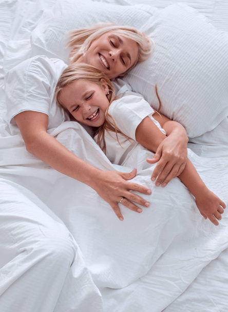 Close-up. gelukkige moeder met haar dochter wakker worden samen - Foto, afbeelding