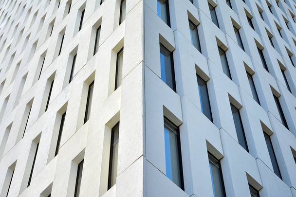 Nowoczesny budynek biurowy szczegółowo. Widok perspektywiczny geometrycznych kątowych okien betonowych na elewacji modernistycznej budynku w stylu brutalistycznym.  - Zdjęcie, obraz