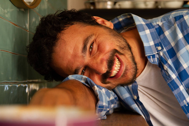 Mladý muž opřený o stůl v kavárně s úsměvem - Fotografie, Obrázek
