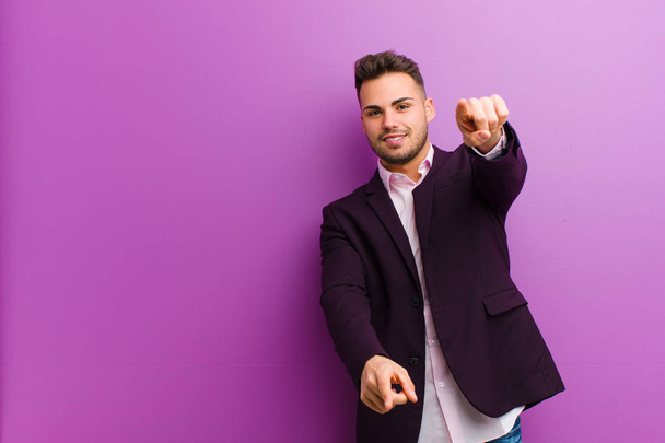 young hispanic man feeling happy and confident, pointing to camera with both hands and laughing, choosing you - Foto, immagini