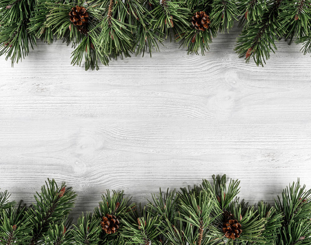 Christmas Fir branches with pine cones on white wooden background. Xmas and Happy New Year theme. Flat lay, top view - Photo, Image