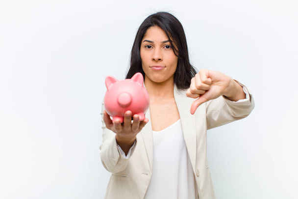 young hispanic pretty woman with a piggy bank - 写真・画像