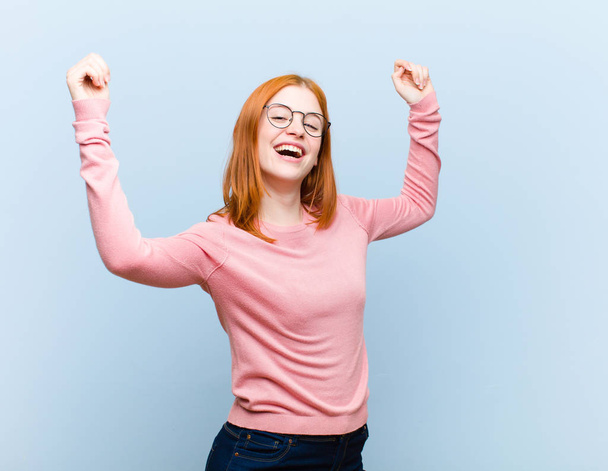 young red head pretty woman shouting triumphantly, looking like excited, happy and surprised winner, celebrating - Foto, Bild