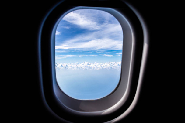 Vue à travers une fenêtre d'avion à réaction haute sur le ciel bleu
 - Photo, image