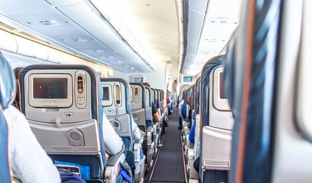 Intérieur de l'avion avec passagers sur des sièges en attente de décollage
 - Photo, image
