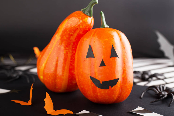 jack-o'-lantern with spider, paper bats, pumpkin ribbons, confetti on black background. Halloween party invitation, celebration. Halloween decorations concept. - Fotoğraf, Görsel