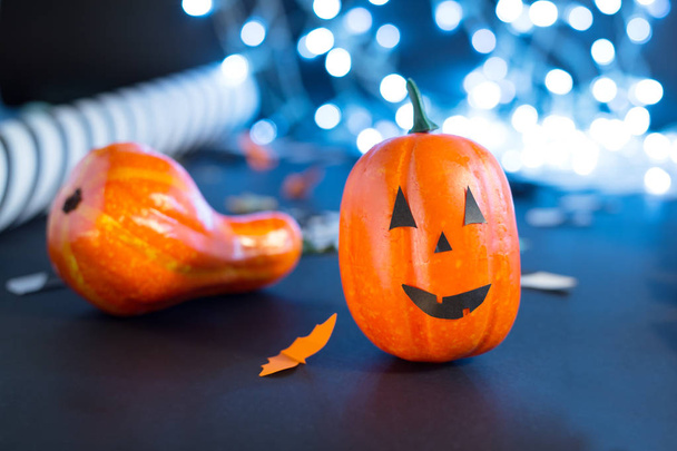 jack-o'-lantern with paper bats, pumpkin ribbons, confetti on black background with lights. Halloween party invitation, celebration. Halloween decorations concept. - Fotoğraf, Görsel