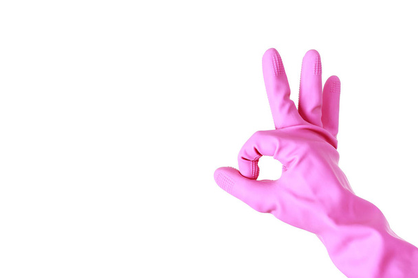 Main féminine en gants de caoutchouc rose montre le signe OK sur un fond blanc
 - Photo, image