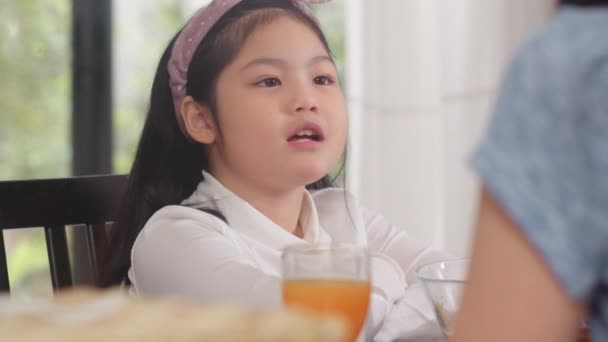 Asijská japonská dcera znuděná jídlem. Životní styl děti smutné nesnáší jídlo nepříjemné snídaně jídlo v kuchyni doma po ránu. Zpomalený záběr. - Záběry, video