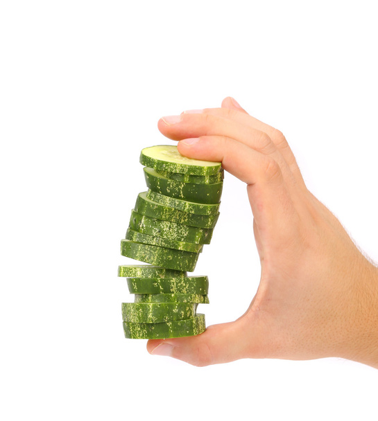 Hand holds stack of sliced cucumber. - Fotó, kép